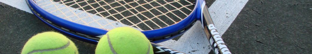 A tennis racket and ball on the court.